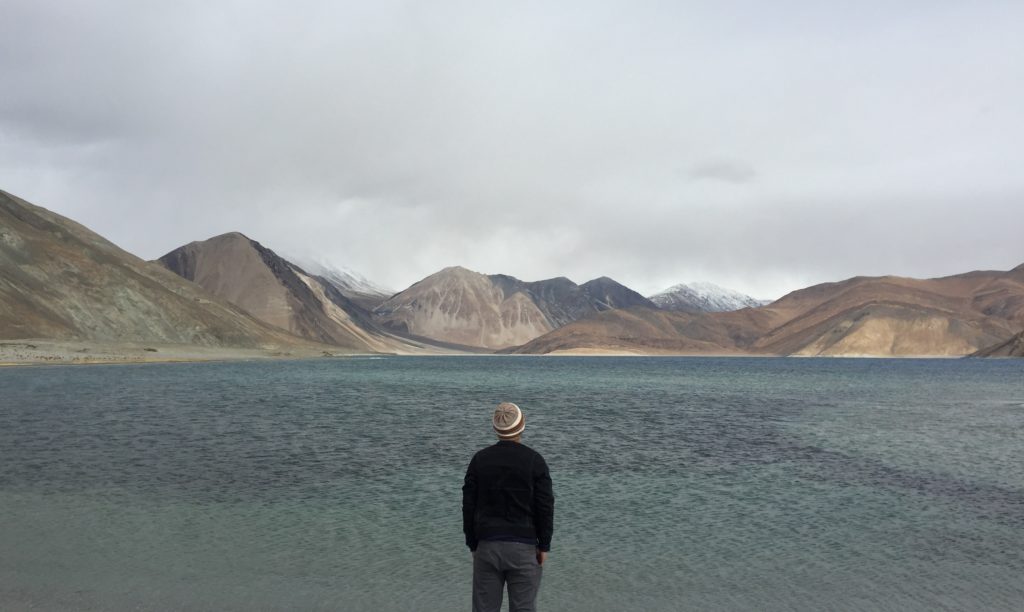 man staring at view lake mountains