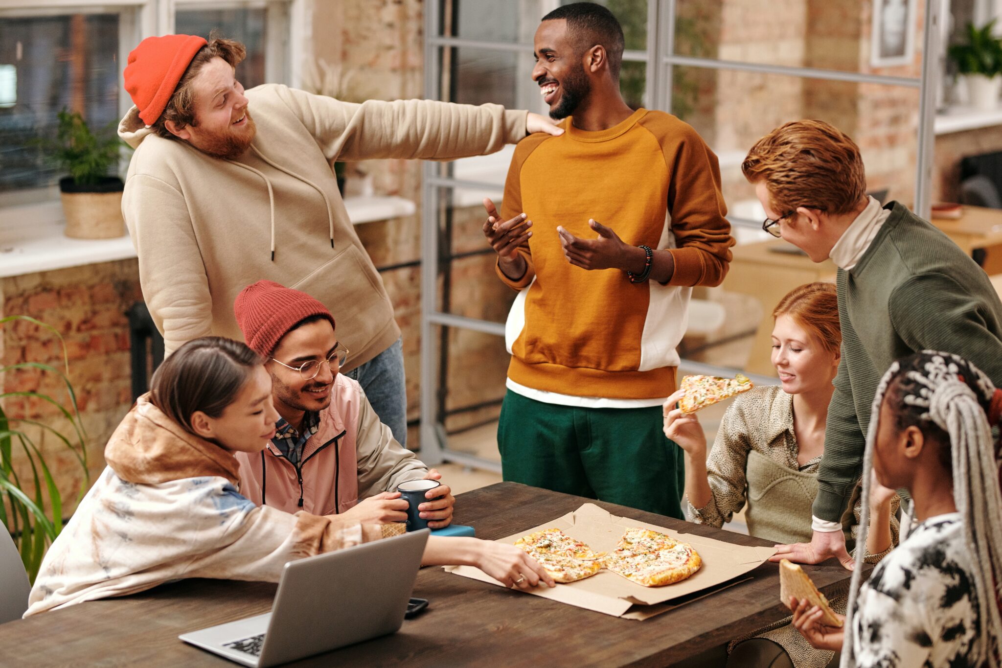 friends around a table working casually and talking having fun